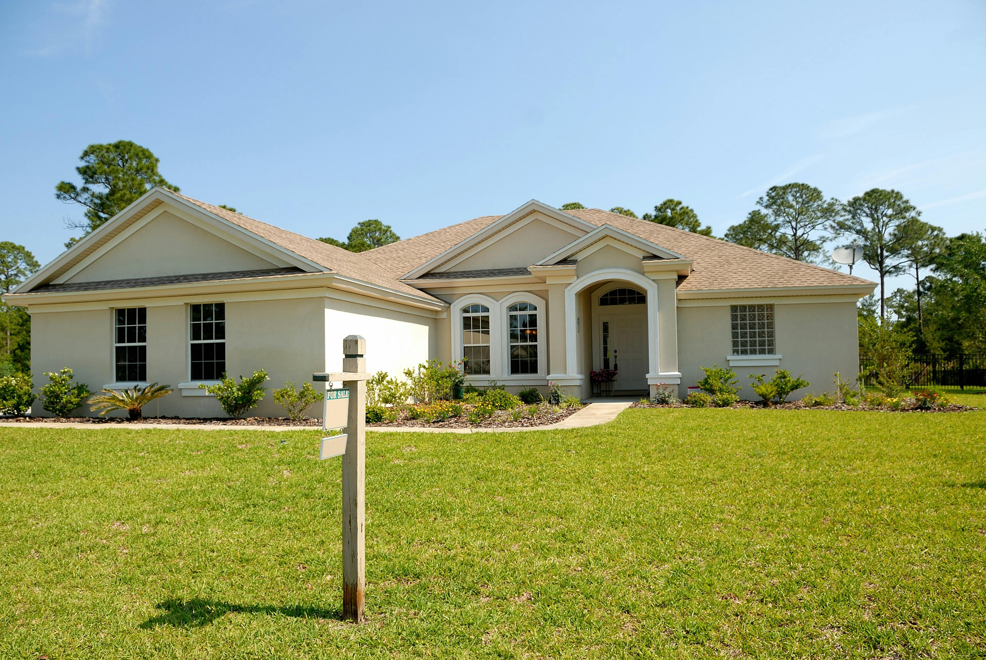 A single-family home with a for-sale sign on the front lawn, representing the residential and commercial real estate closings Osman Law handles in Erath County, TX